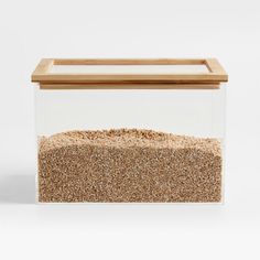 a glass container filled with sand on top of a white surface