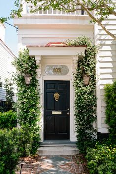 a black front door surrounded by greenery