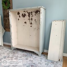 an old white cabinet sitting on top of a rug next to two other pieces of furniture