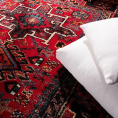 a red rug with white pillows on it