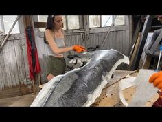 a woman is working on an animal in a shop