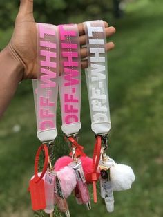 someone is holding up three key chains with the words happy new year on them in pink and white