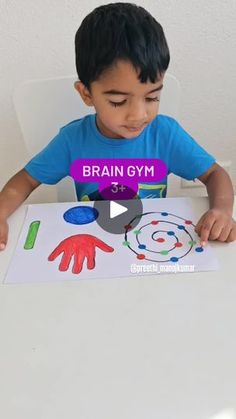 a little boy sitting at a table with a piece of paper in front of him