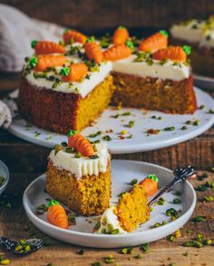 carrot cake with white frosting and green sprinkles on two serving plates