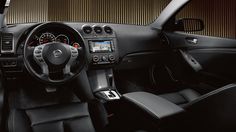 the interior of a modern car with black leather seats and dashboard, including steering wheel