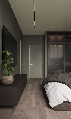 a bed sitting in a bedroom next to a plant on top of a wooden floor