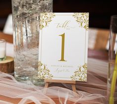 the table numbers are placed on top of each other in front of glasses and candles