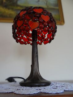 a lamp that is on top of a table with a lace doily around it