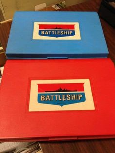 two laptops sitting side by side on top of a wooden table, with the words battleship and battle ship stickers on them