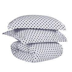 three pillows stacked on top of each other with black polka dot print and white sheets