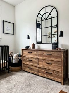 a wooden dresser sitting next to a baby crib