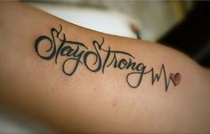 a woman with a tattoo on her arm that says stay strong and heart in cursive writing