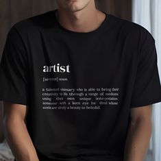 a man wearing a black t - shirt with the words artist printed on it in white