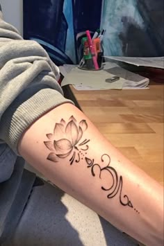 a woman's arm with a flower tattoo on the side of her left arm