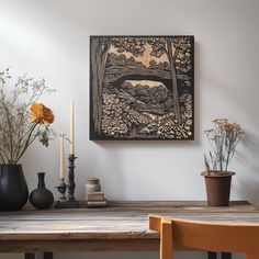 a wooden table topped with vases filled with flowers next to a painting on the wall