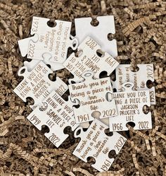 white puzzle pieces with words on them sitting in the middle of some wood shavings