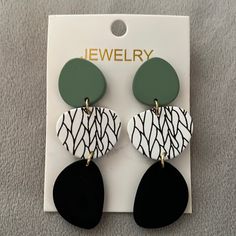 the earrings are black, white and green with an abstract design on it's ear