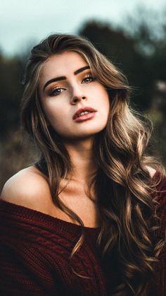 a beautiful woman with long hair posing for the camera