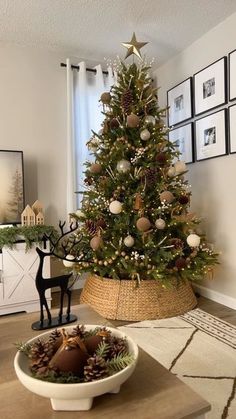 a decorated christmas tree in a living room next to a bowl with ornaments on it