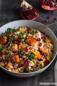 a white bowl filled with food next to pomegranate