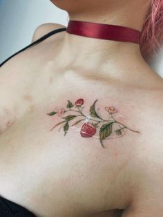 a woman's chest with flowers and leaves tattooed on her left side ribcage