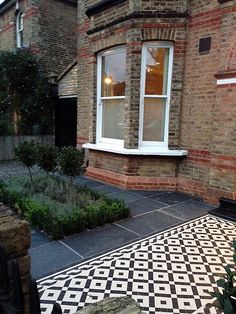 a black and white checkered rug in front of a brick building