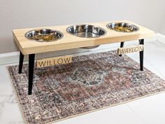 a dog bowl stand with three bowls on it and the words willow written in large letters