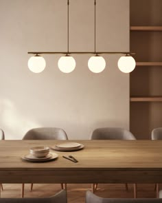 a wooden table with plates and cups on it in front of a bookshelf