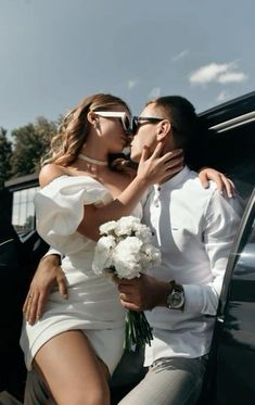 a man and woman sitting on the back of a car