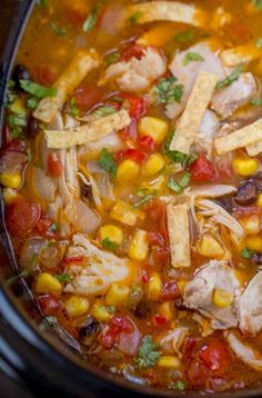 a crock pot filled with chicken tortilla soup and garnishes