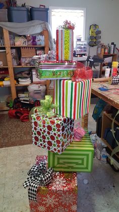 many wrapped presents are stacked on top of each other in the room with shelves and tables