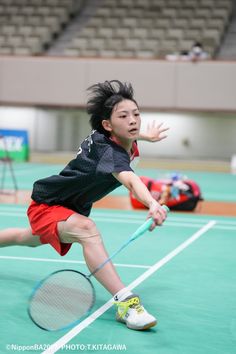 a young boy is playing tennis on the court