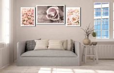 a living room with a couch and two pictures on the wall above it that have flowers in them