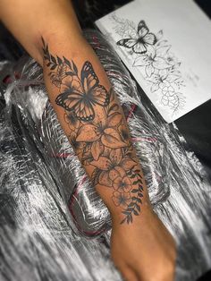 a woman's foot with flowers and butterflies on it