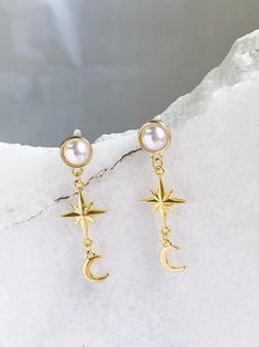 MEROPE Earrings Celestial theme, star and moon earrings, Winter Earrings Material: pearl, gold plated brass Dimensions:  4,5*1,5 cm / 1.77*0.59 in  Weight: 3 gr / piece For hygienic reasons, ALL EARRINGS cannot be return All PURE GREEK Jewels are inspired from the ancient greek arts, folkore traditions and world cultures. Our jewelry are handmade with love and imagination so you can enjoy unique creations.  I use mineral and semi-precious stones, crystals, real pearls, gold plated brass metal, wooden elements, greek and oriental charms, pompons and feathers. I only use high quality materials that guarantee great comfort and longevity to our jewels.  *Keep in mind that our jewelries can present minor differences from the model depicted in shape or color according to availability of material Cheap Moon Shaped Party Jewelry, Luxury Moon-shaped Celestial Earrings, Cheap Celestial Dangle Jewelry, Uni Clothes, Star And Moon Earrings, Greek Mythology Jewelry, Cosmic Jewelry, Celestial Theme, Ancient Greek Jewelry