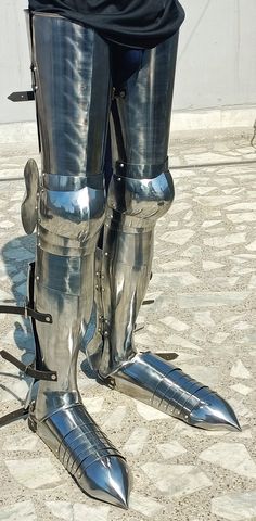 the legs and ankles of a man in armor