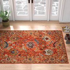 an orange rug on the floor in front of a door