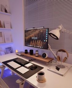 a desk with a monitor, keyboard and headphones on it