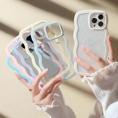 a woman holding up her phone case with multiple colors