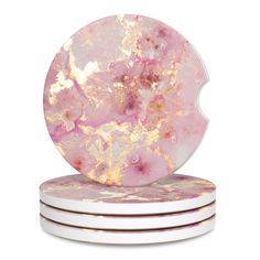 pink and gold marble coasters stacked on top of each other in front of a white background