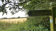 there is a sign that says thames path public footpath on the side of the road