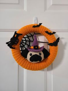 a crocheted halloween wreath with a pug wearing a witches hat on it