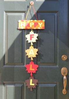 a happy fall sign hanging on the front door