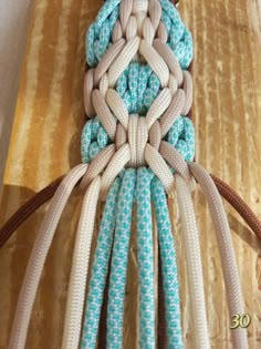 a close up of a piece of cloth with ropes attached to it on a wooden surface