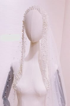 a mannequin wearing a veil with pearls on it