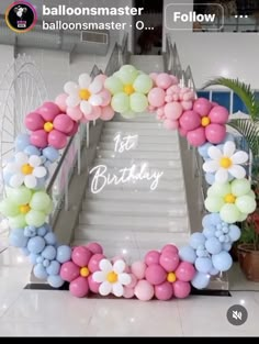 balloons are arranged in the shape of a wreath on top of a staircase with flowers