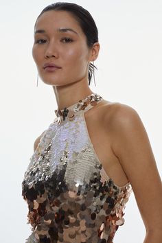 a woman in a sequin dress poses for the camera