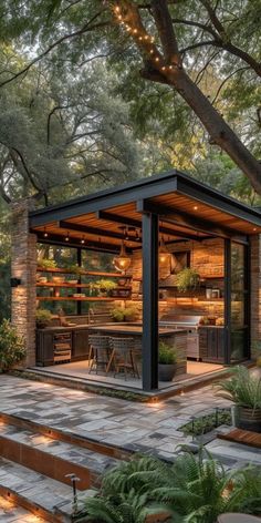 an outdoor kitchen is surrounded by trees and plants