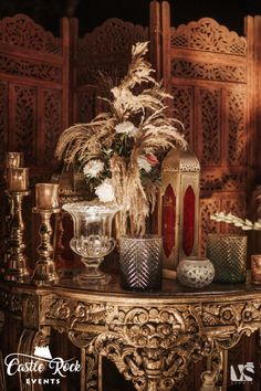 a table topped with vases filled with flowers and other decorative items on top of it