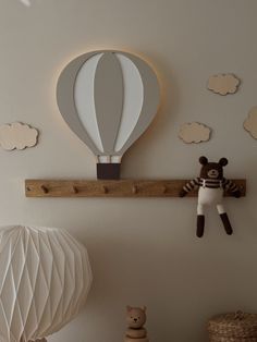 there is a stuffed bear on the shelf next to a hot air balloon wall decoration